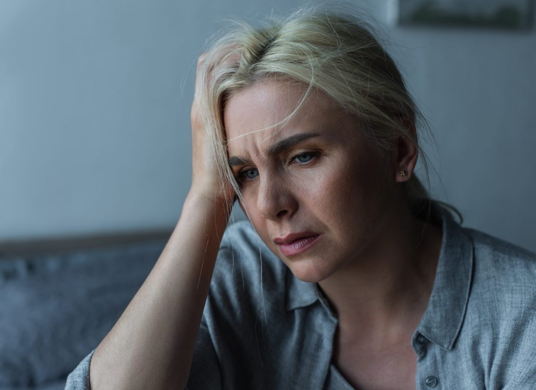 Exhausted blonde woman having migraine during menopause